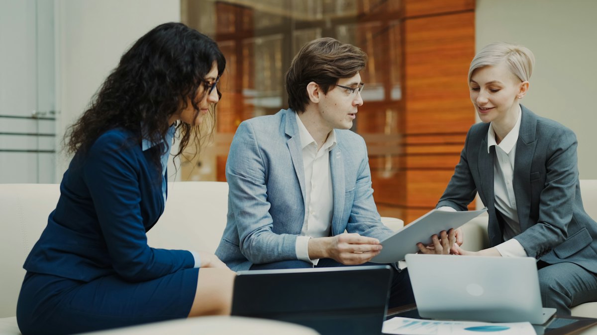 Three professionals discussing documents