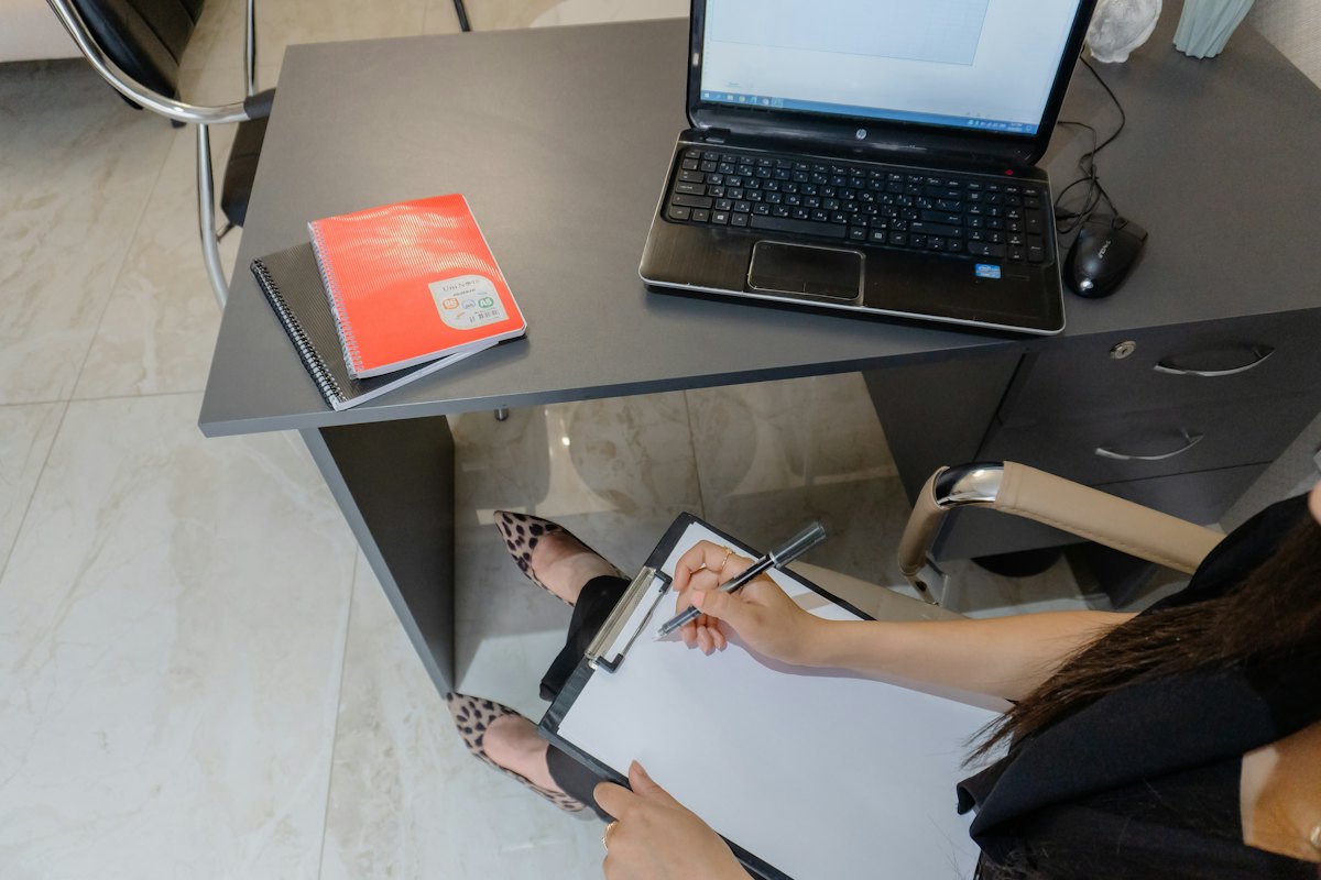 Writing on a clipboard at a desk